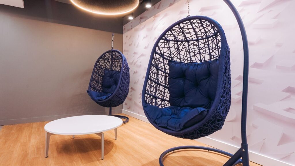 Sala de descanso em empresa de tecnologia com duas cadeiras de balanço.