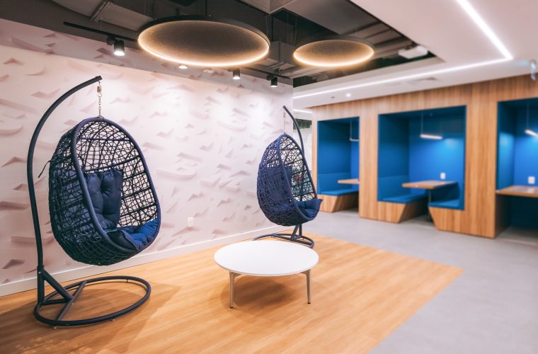 foto de 2 cadeiras de balanço com salas privativas no fundo, em um escritório de tecnologia